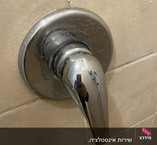 ידית ברז מתכתית עם סימני מים